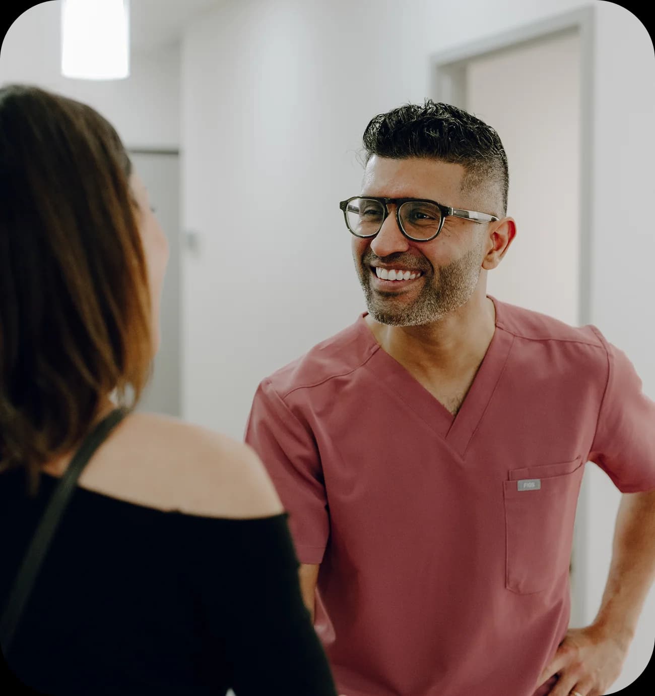 A dentist speaking with a patient before a first appointment