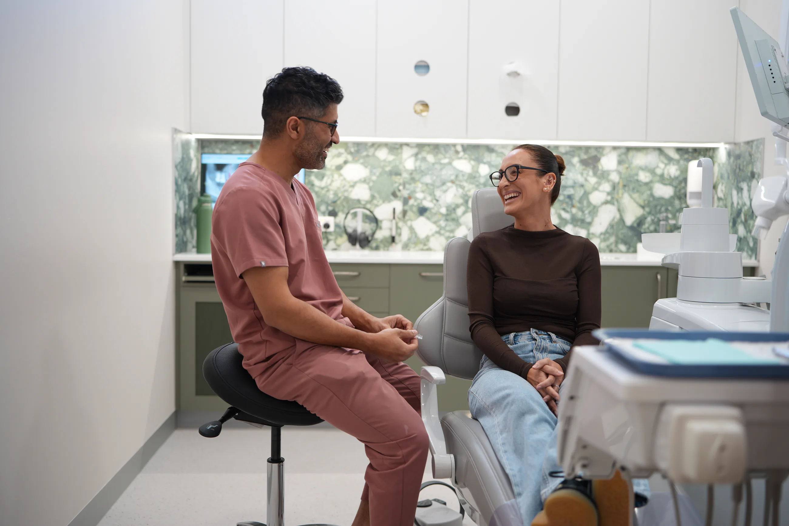 A dentist speaking with a patient before a first appointment
