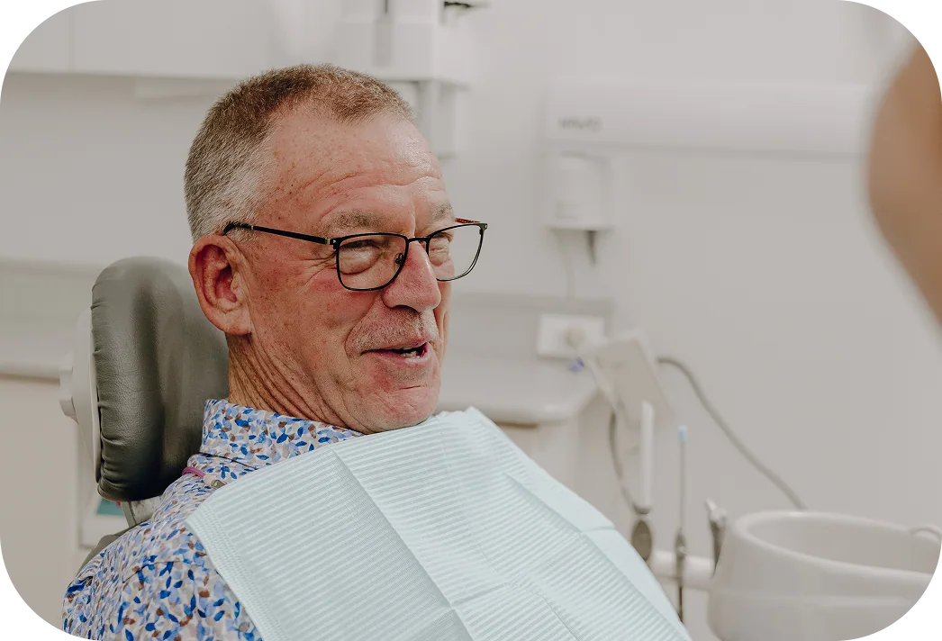 A dentist reviewing full arch implant planning imagery with a patient