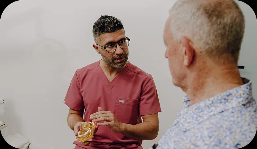 Hands adjusting a denture model in a dental lab setting